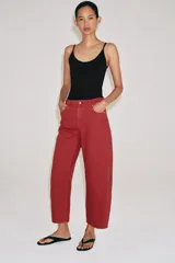 Jeans capri de tiro medio y pernera balloon, color rojo ladrillo. Confeccionados en denim, cuentan con trabillas en la cintura, bolsillos delanteros y traseros, y cierre frontal con cremallera y botón metálico.