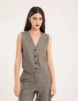 Chaleco de vestir gris oscuro con textura tipo tweed, escote en V y botones frontales. Corte levemente entallado y largo a la cintura.