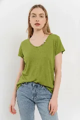 Remera de lino color verde lima, con escote redondo y detalle de cuatro botones decorativos en el lateral del escote.