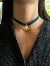 Gargantilla tipo choker de cinta de terciopelo color azul con dije de cruz metálica en acabado plateado.