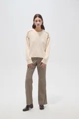 Sweater de algodón color natural, de corte holgado y cuello redondo. Presenta detalles de costuras decorativas con bordado en los hombros y puños acanalados.