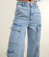 Pantalón estilo años 90 de tiro alto confeccionado en jean, con bolsillos cargo en los laterales y trabillas en la cintura.
