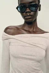 Top de manga larga confeccionado en tejido de algodón, con diseño de escote asimétrico y corte ajustado al cuerpo.