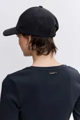 Remera de manga larga color negro, con cuello redondo y cierre frontal parcial con botones metálicos.