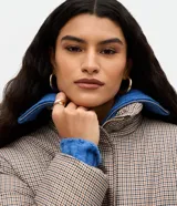 Campera puffer Marfinno con estampa de cuadros mini en tonos beige y negro, de corte recto, cuello alto y cierre frontal con cremallera. Cuenta con mangas largas y forro interior.