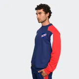 Buzo de entrenamiento Umbro, color azul marino, con diseño de bloques de color en hombros y mangas (rojo y blanco). Presenta el logo de Umbro y el escudo del Club Nacional de Football en el pecho.