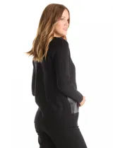 Cardigan de punto negro con escote en V, cierre frontal mediante herraje metálico y detalles de ribetes y bolsillos aplicados en cuero sintético.