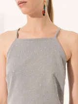 Vestido largo de punto gris con brillo, corte al cuerpo en la parte superior con breteles finos y espalda tipo halter, y falda evasé.