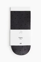Medias panty negras con patrón de lunares pequeños en relieve.