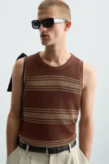 Camiseta sin mangas (manga sisa) de punto, color marrón con rayas horizontales en tono beige/tostado. Presenta cuello redondo con acabado en rib.