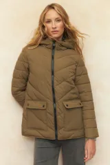 Campera puffer color verde oliva, con capucha, cierre frontal, bolsillos laterales con solapa y elástico en la cintura.