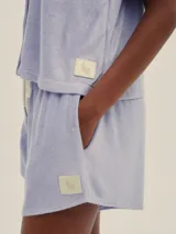 Camisa color crema de tela toalla con botones de madera, corte recto y mangas cortas.