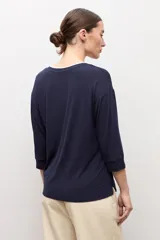 Remera color marrón topo de manga tres cuartos, con escote en V y detalle de ribete blanco en el cuello.