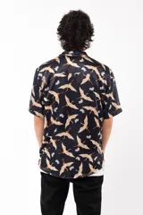 Camisa negra con estampado de grullas y flores, de manga corta y corte relajado, con cuello tipo sastre.