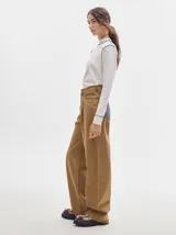 Polera de manga larga confeccionada en tela rib color bordó, con cuello alto y hombreras. Presenta costuras a la vista con pespuntes en hilo de color contrastante en el cuello, puños, hombros y ruedo.