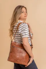 Bandolera mediana de cuero sintético color negro, con correa regulable, bolsillo frontal con cierre y compartimento principal.