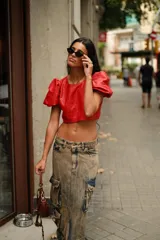 Top corto de cuero rojo con cuello redondo y mangas cortas abullonadas.