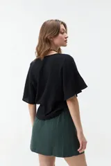 Blusa negra de manga corta con escote en V y diseño amplio y ligero.