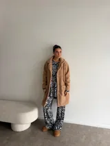 Tapado de textura tipo peluche, color camel, con solapas clásicas, cierre frontal de botones y bolsillos laterales.