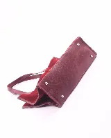 Bolso tipo shopper de gran tamaño, confeccionado en cuero gamuzado color marrón. Presenta estructura rectangular con bordes reforzados en cuero liso oscuro, doble asa de hombro y cierre mediante botón magnético.