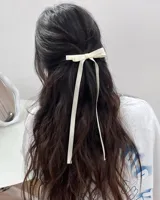 Par de hebillas para el pelo con moño de cinta de grogrén negro y tiras largas.