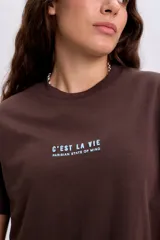Remera marrón de manga corta con cuello redondo y estampa frontal en color celeste con la leyenda "C'est La Vie Parisien State of Mind".