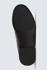 Mocasín de vestir tipo penny loafer en color bordó con acabado desgastado, diseño de antifaz en el empeine y suela de goma a contraste con pequeño tacón.
