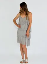Vestido corto gris con breteles finos y volados en capas.