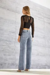 Blusa crop top negra con mangas largas de encaje y corpiño estructurado.