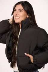 Campera bomber de nylon color negro, con cuello alto, cierre frontal y puños elásticos.