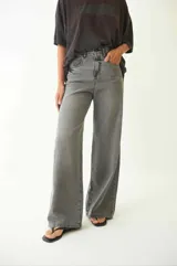 Pantalón de jean con corte baggy de tiro medio, diseño de cinco bolsillos y acabado desgastado en tono gris oscuro.