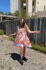 Vestido corto sin mangas con estampado abstracto en tonos naranja y celeste.