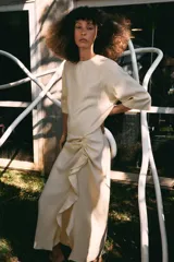 Vestido midi de Zara Woman Collection, confeccionado en mezcla de viscosa, con cuello redondo, manga corta y detalle de drapeado lateral con volado. Presenta bajo asimétrico y cierre en la espalda.
