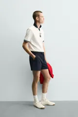 Shorts de corte sastrero confeccionados en tejido de piqué elástico, con cierre frontal de cremallera y gancho metálico oculto, y bolsillos laterales.