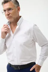 Camisa de vestir azul con cuello abotonado, corte clásico y mangas largas.