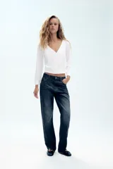 Jeans ZW Collection de corte curved straight y tiro medio, confeccionados en denim azul oscuro con efecto lavado. Presentan diseño de cinco bolsillos, trabillas para cinturón y bajo asimétrico con terminación sin rematar. Cierre frontal con cremallera y botón metálico.