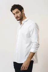 Camisa de vestir de manga larga en color blanco, con cuello clásico y cierre frontal de botones.
