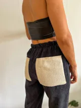 Pantalón de pana negro con bolsillos traseros de pana color crema y cintura elastizada.