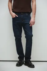 Jeans de tiro medio, corte regular, color azul oscuro, con lavado stone wash y bigotes láser.