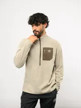 Buzo de entrenamiento Umbro con medio cierre frontal, cuello alto y bolsillo en el pecho de nylon con cierre. Presenta una textura sutil en el tejido y logo de la marca estampado en el bolsillo.