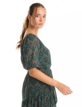 Vestido midi de gasa estampada con diseño de hojas, escote en V cruzado y mangas cortas fluidas. Presenta cintura elastizada con lazo ajustable y falda con volados escalonados que aportan movimiento. Incluye forro interno a tono.