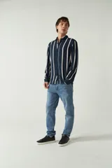 Camisa de mangas largas con estampado a rayas verticales en tonos verde oliva, blanco y azul. Corte regular y logo bordado en el pecho. Confeccionada en viscosa.