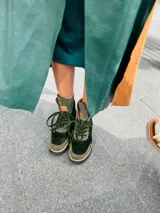 Borcegos de gamuza y terciopelo color azul marino, con detalles en color cobre y suela de goma negra. Cierre con cordones.