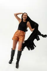 Ruana de lana merino en color tostado, con diseño de punto texturizado y terminación de flecos en el ruedo.