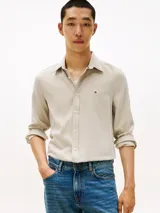 Camisa de manga larga Tommy Hilfiger de corte slim, confeccionada en tejido de piqué Oxford con tecnología de regulación de temperatura. Presenta cuello inglés, cierre frontal con botones y el logo de la marca bordado en el pecho.