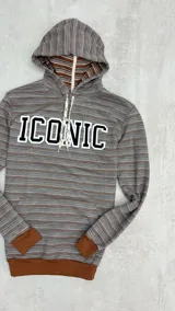 Canguro rústico a rayas horizontales en tonos marrón y gris, con capucha forrada, puños y cintura en color marrón liso. Estampa frontal con la palabra "ICONIC" en letras blancas con borde negro.