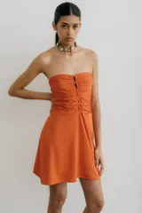 Vestido corto strapless color naranja, con frunce en el frente y falda semi acampanada.