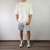 Short de algodón color beige melange, de diseño cómodo y holgado con bolsillos laterales y terminación descosida en las perneras.