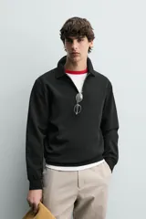 Sudadera polo de corte regular, confeccionada en tejido técnico interlock de algodón con elasticidad. Presenta cuello solapa, cierre frontal de cremallera y manga larga con puños acabados en rib.