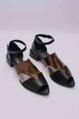 Sandalias de cuero color marrón, con combinaciones de color beige y naranja. Tiene tira ajustable con hebilla en el tobillo y taco bajo.